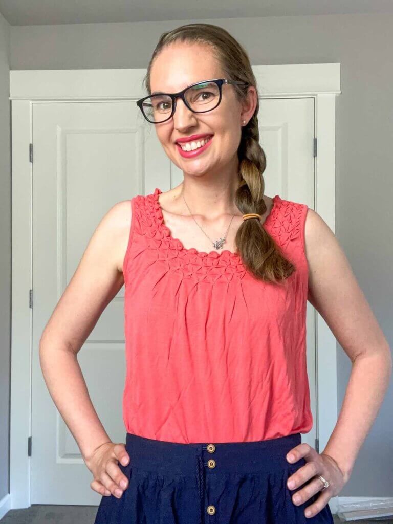 This is what the coral pink tank top looks like when I did a Wantable try on. Image of a woman wearing a coral pink tank top and blue skirt.