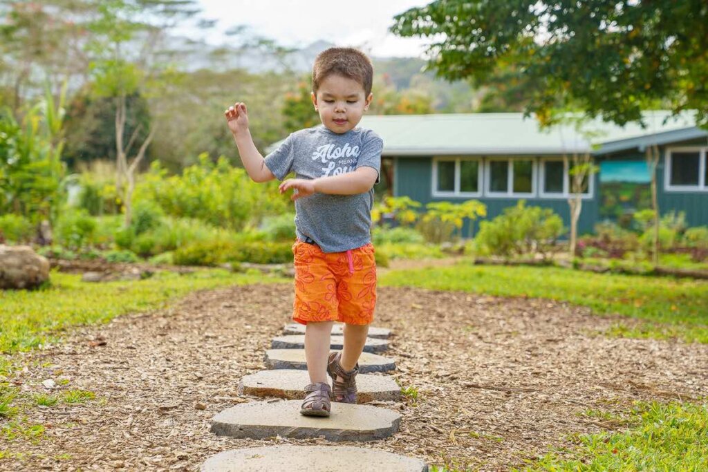 Image of a boy walking on stones on the North Shore Kauai Food Tour.