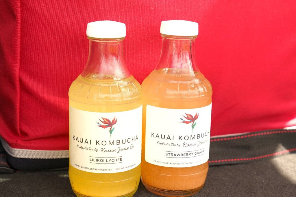 The first stop of the Tasting Kauai Food Tour is at Kauai Juice Co in Kilauea. Image of two bottles of Kauai Kombucha from Kauai Juice Co.