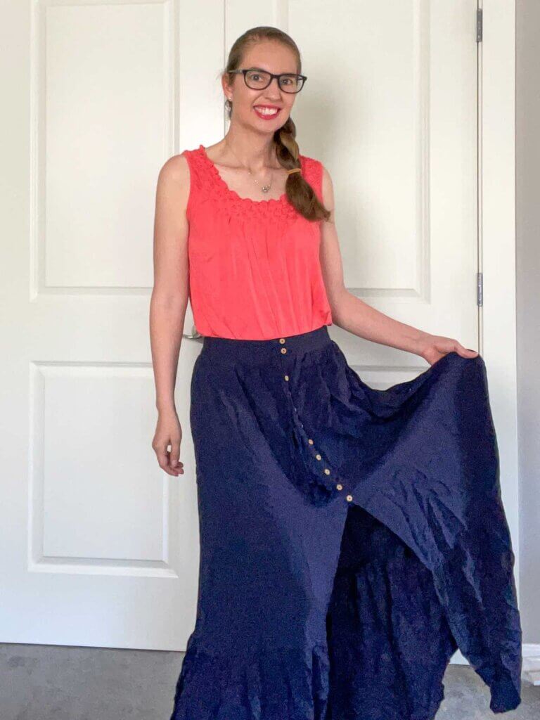 Image of a woman wearing a navy maxi skirt with a slit up the front.