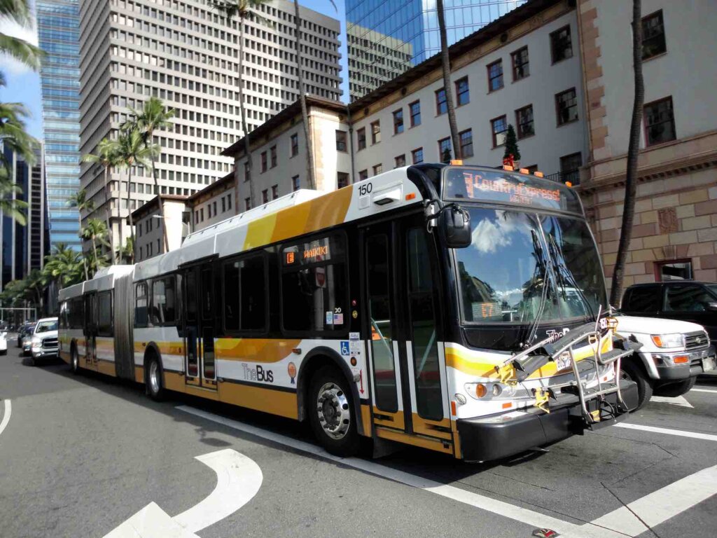 TheBus is the best public transportation on Oahu. DaBus2 is an app that displays bus route info. Image of TheBus driving on Bishop Street in Honolulu.