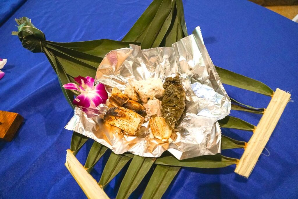 This Waimea Valley luau features Samoan food. Image of a leaf bowl with traditional Samoan food inside.