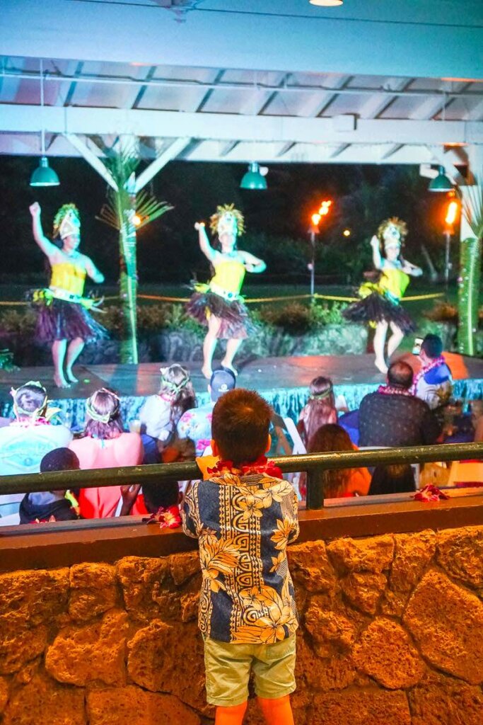 Image of a boy watching a North Shore luau on Oahu.