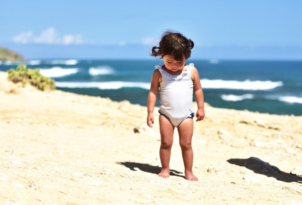 Find out the best babysitters on Kauai  recommended by top Hawaii blog Hawaii Travel with Kids. Image of a toddler on a Kauai beach.