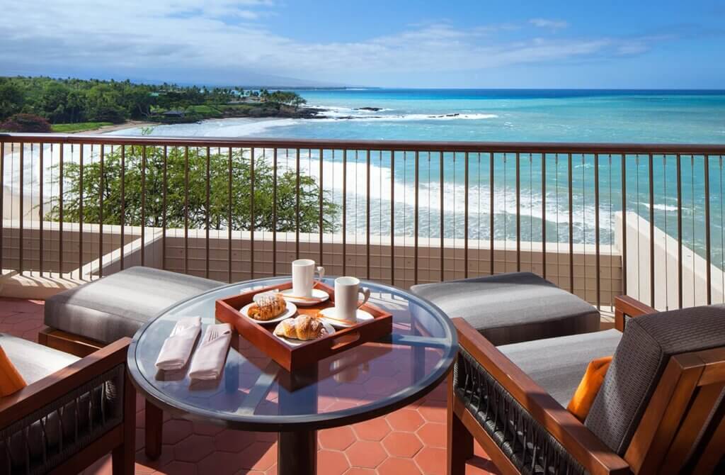The Mauna Kea Beach Hotel is one of the best places to stay in Big Island Hawaii with kids. Image of the lanai overlooking the ocean.