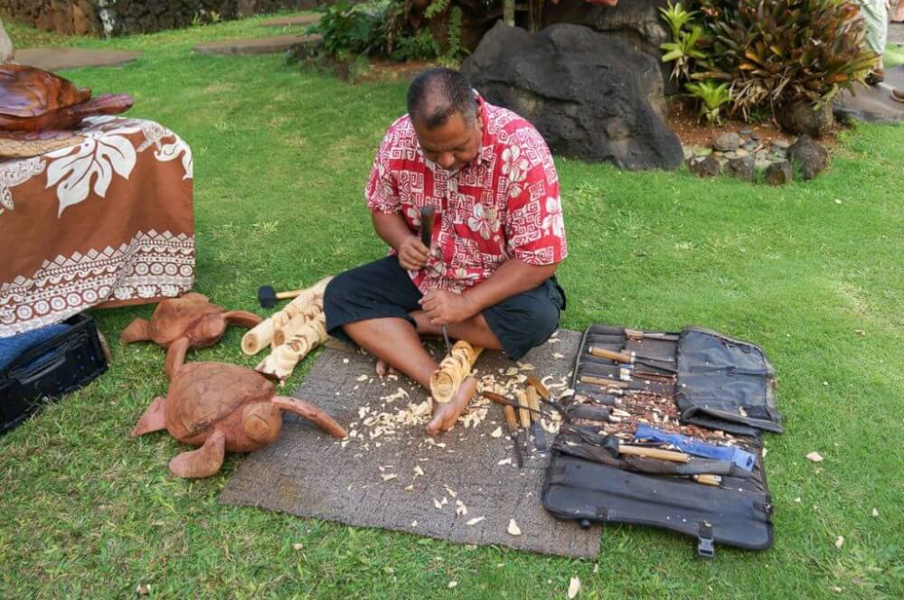 You'll have the opportunity to see Hawaiian artisans like this one carving wood sculptures.