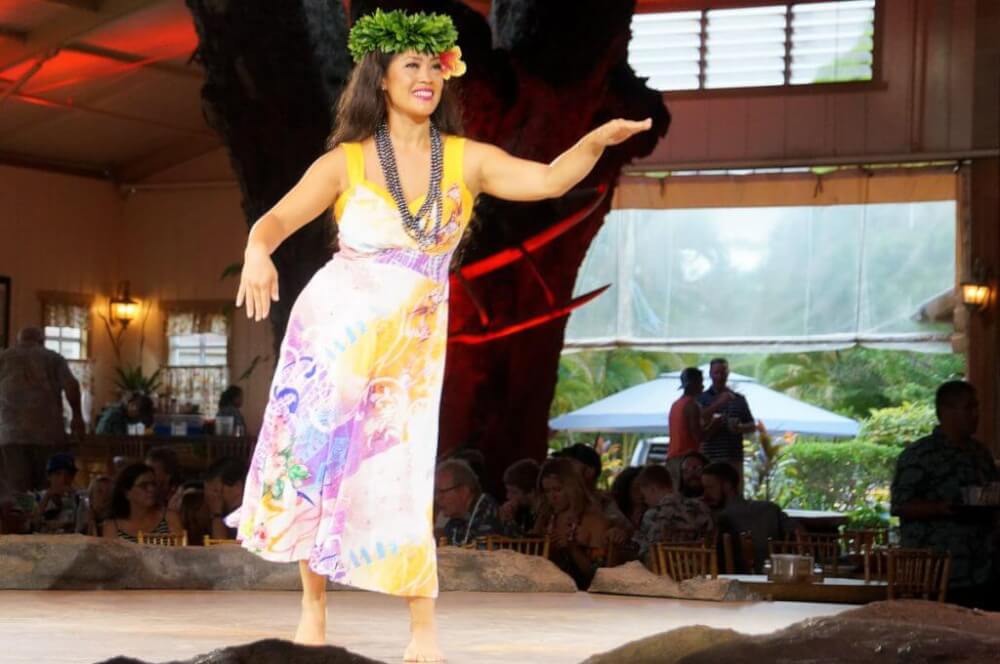 This Kauai luau offers hula dancing during dinner and then an after dinner theatrical show. Image of a woman hula dancing on stage.