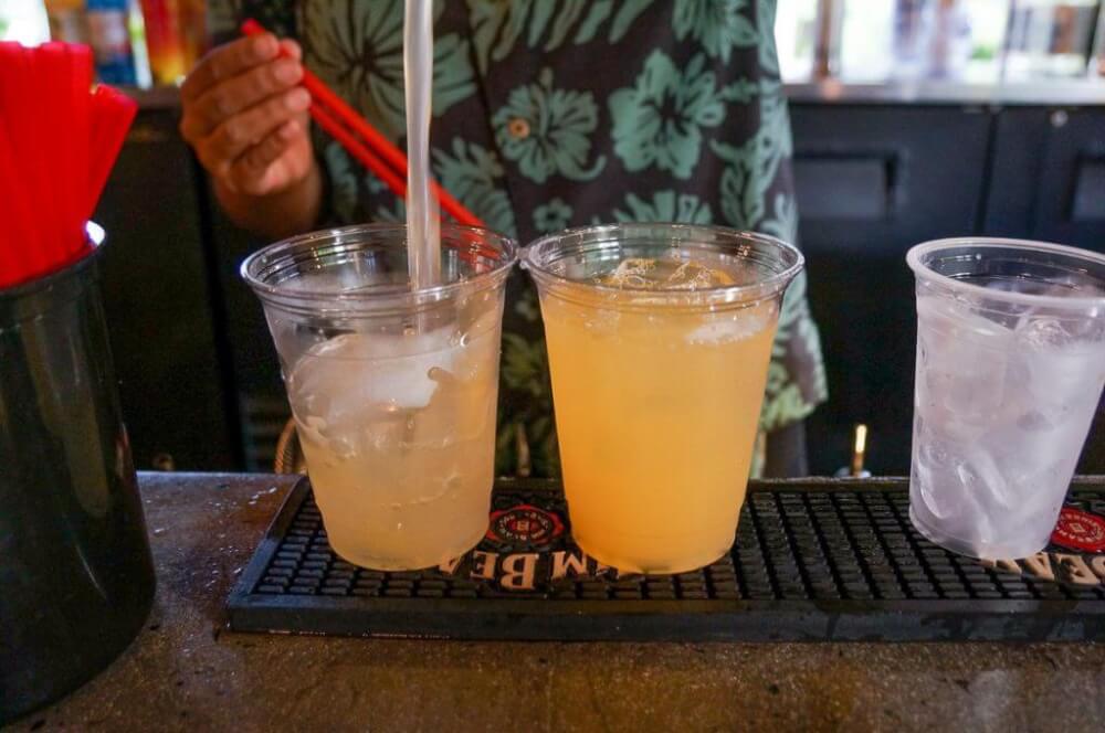 Photo of someone in an Aloha shirt pouring drinks at a Kauai luau.