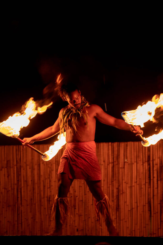 Check out the Ahi Lele Fire Show if you want to see Hawaiian fire dances. Image of a man with 2 fire torches.