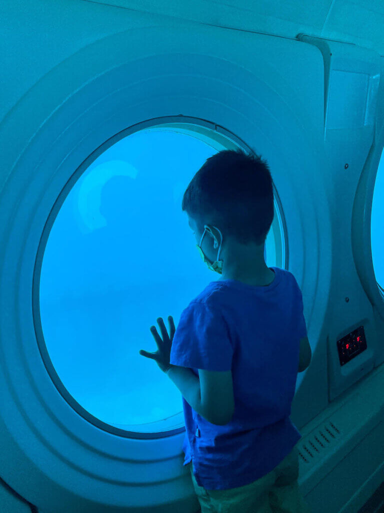 The Waikiki submarine is one of the best kid friendly things to do in Waikiki. Image of a boy in a submarine.