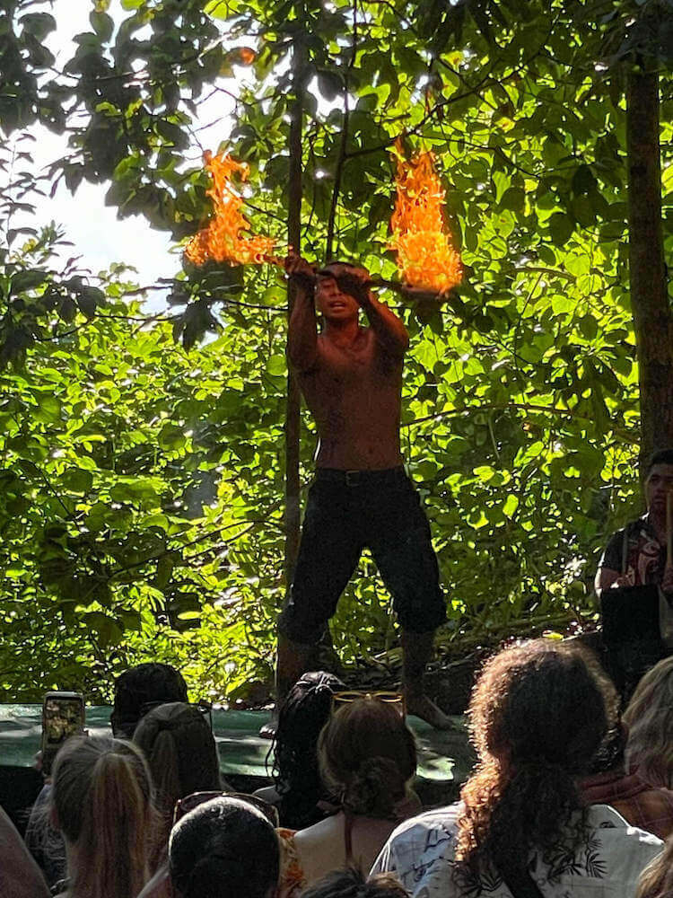 See Samoan fire dancing at the Experience Nutridge Luau on Oahu. Image of a Samoan fire knife dancer in the jungle.