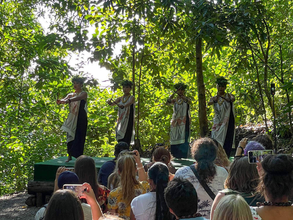 Image of 4 women in ancient Hawaiian clothing dancing hula in the jungle.