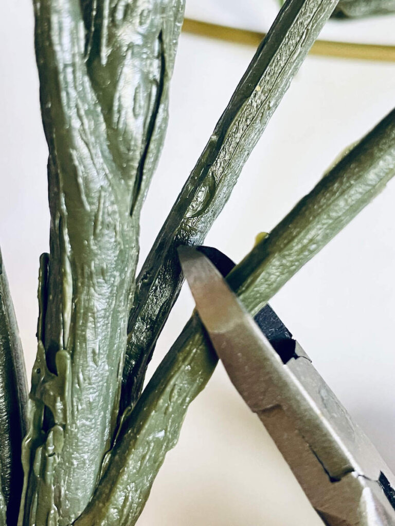 Image of wire cutters clipping the stem of a fake flower.