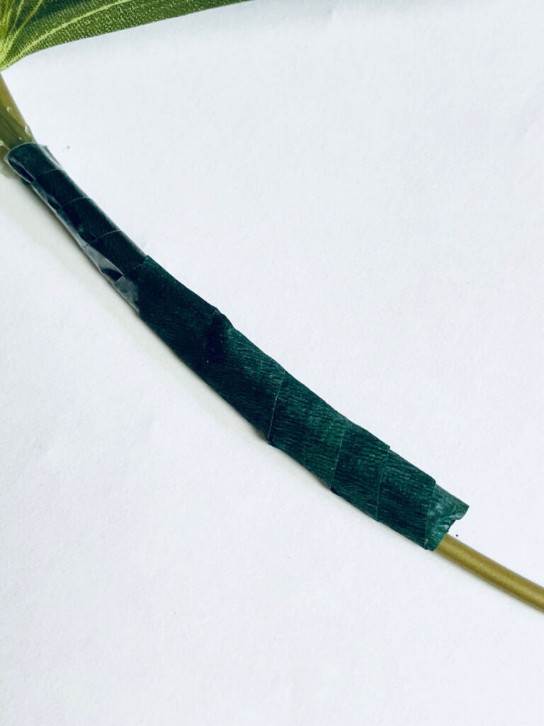 Image of green florist tape wrapped around a gold hoop.