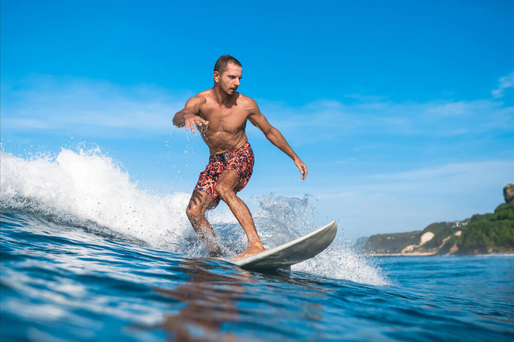 One of the top things associated with Hawaii is surfing! Image of a man surfing in Hawaii.