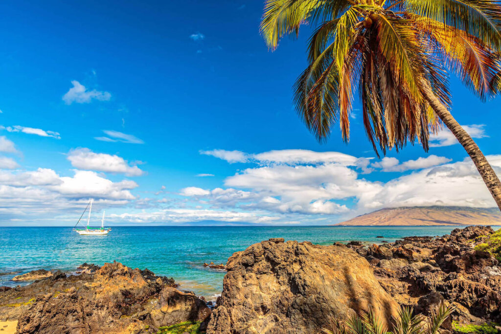 Find out the best things to do in Kihei Maui recommended by top Hawaii blog Hawaii Travel with Kids. Image of a Kihei beach with a boat in the water.