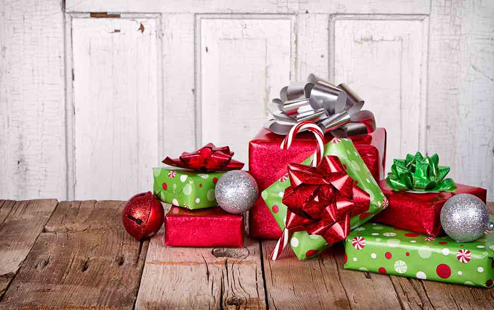 Find out how to handle Christmas presents in Hawaii. Image of a little pile of presents on a wood table.