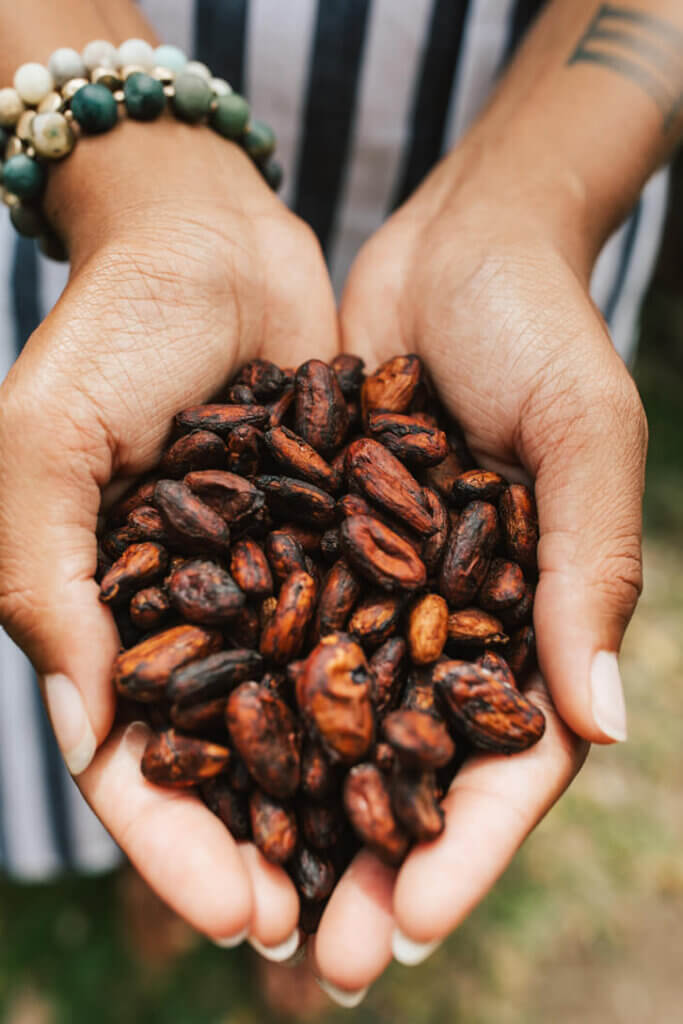 Image of a woman holding a bunch of cocoa beans in her hands. Photo credit: Hawaii Tourism Authority (HTA) / 