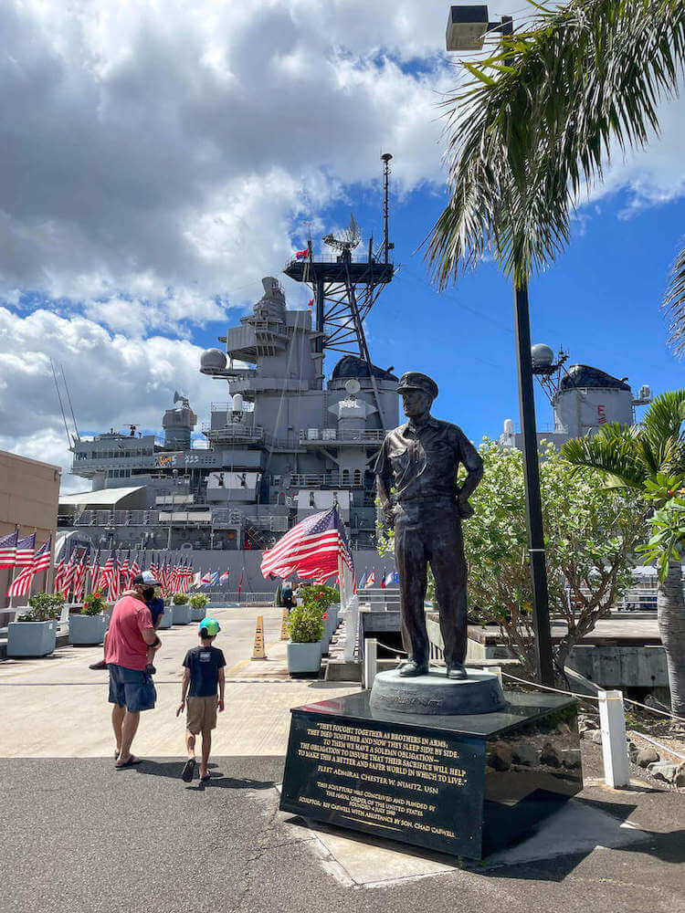 Find out whether or not it's worth visiting Pearl Harbor with kids. Image of a dad and two boys walking through the entrance to the USS Battleship Missouri at Pearl Harbor.