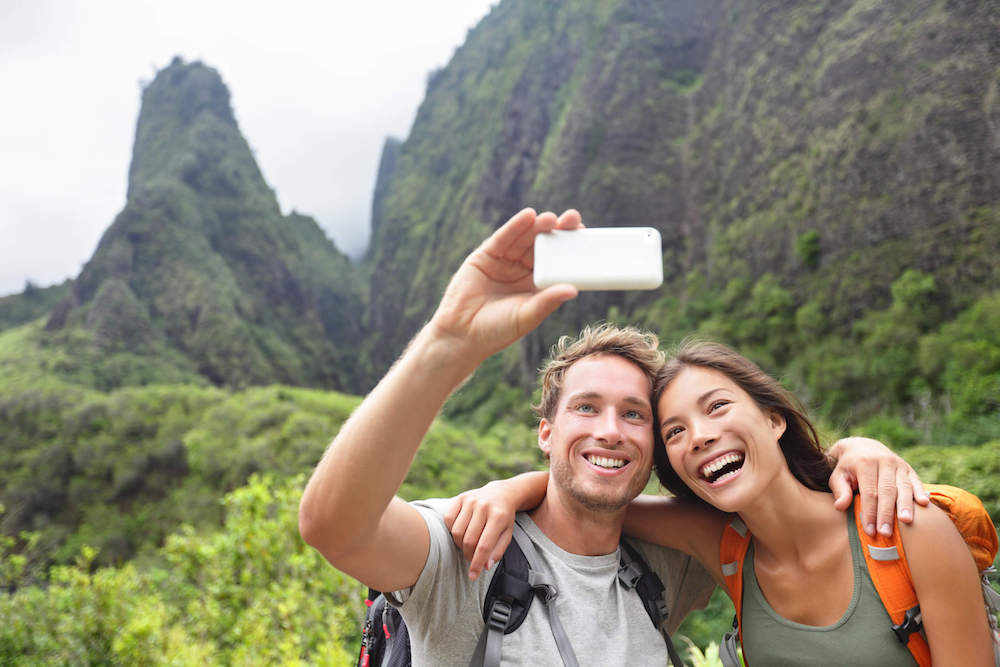 There are plenty of Maui Instagram captions you can use for your Maui selfies! Image of a man and woman taking a selfie at I'ao Needle on Maui.