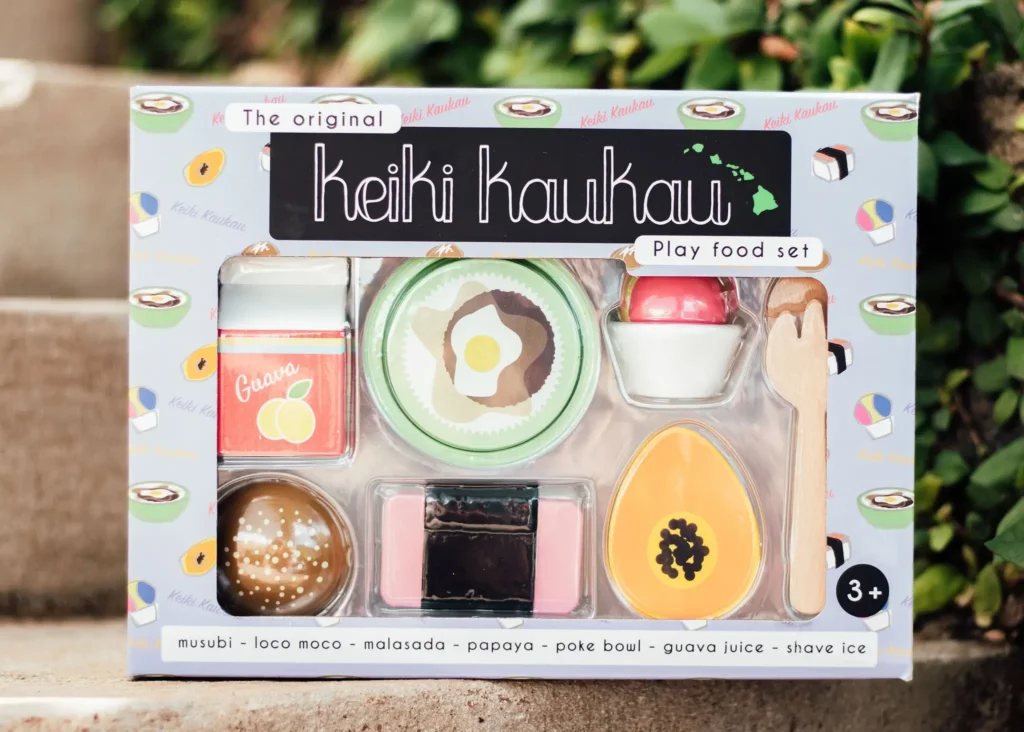 The best Hawaiian toys are made by Keiki Kaukau. Image of a box of wooden food items from Hawaii.