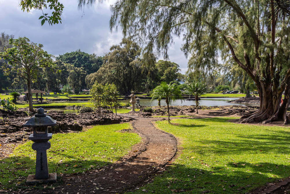 One of the prettiest Hilo botanical gardens is Liliuokalani Gardens. Image of a pathway leading to water in Hawaii.