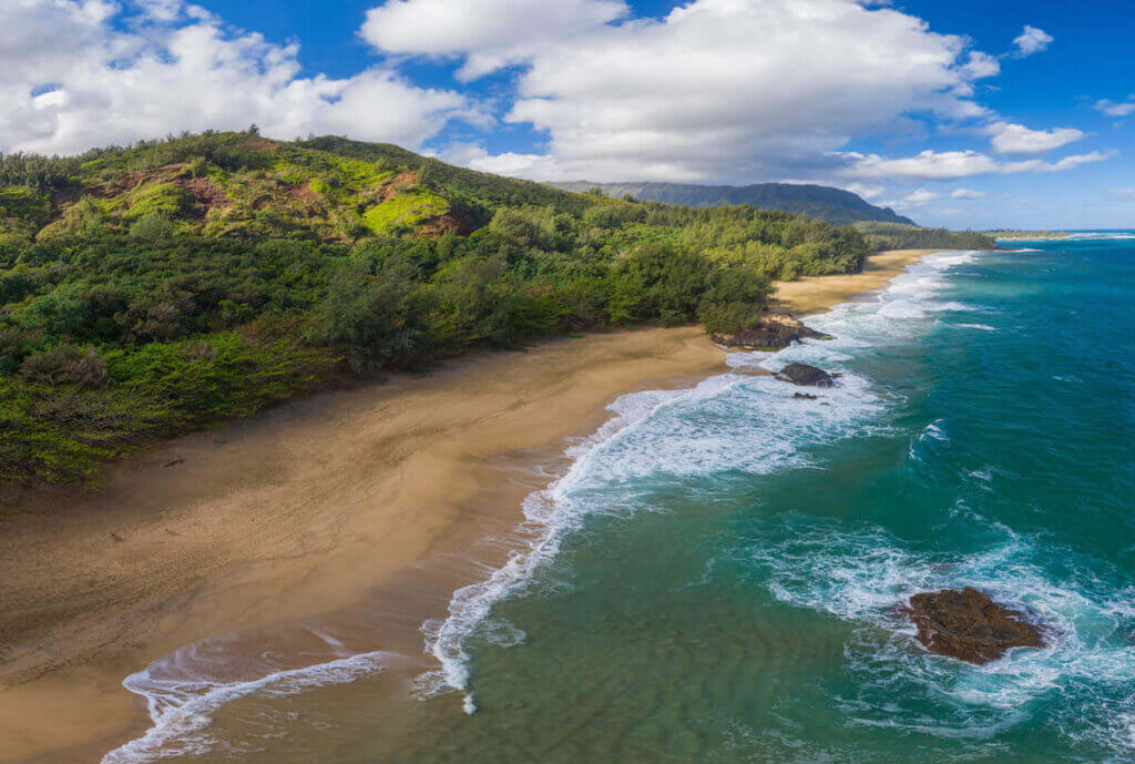 Find out the prettiest Kauai beaches worth seeing by top Hawaii blog Hawaii Travel with Kids. Image of an aerial shot of Lumahai Beach on Kauai's North Shore.