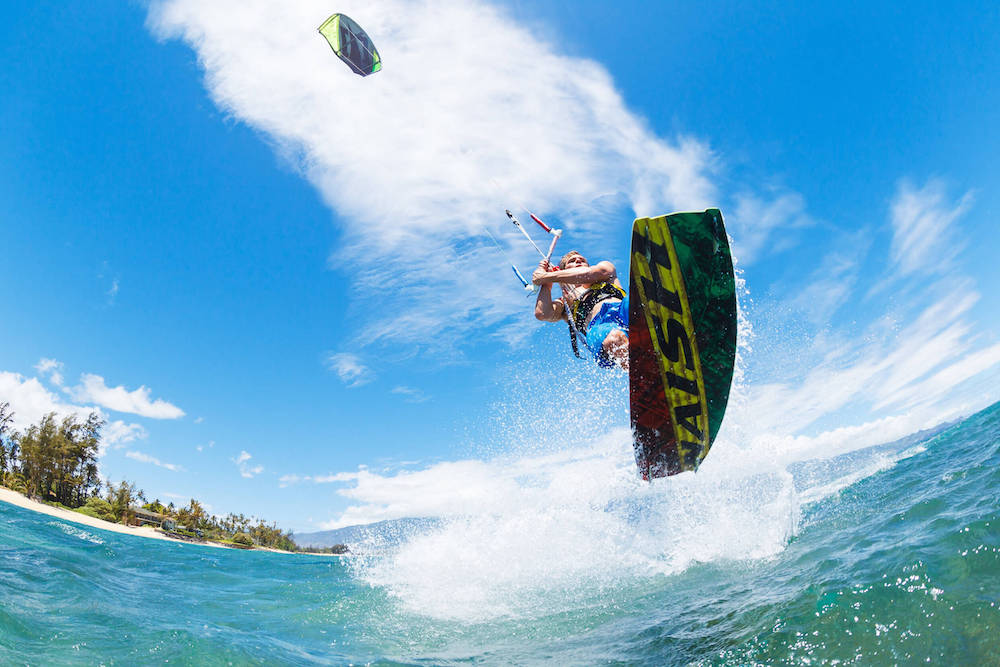 Learn how to kiteboard on Maui with this Maui kiteboarding group lesson. Image of a man kiteboarding on Maui.