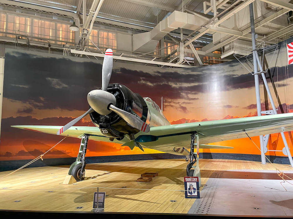 Image of a Mitsubishi A6M2 Model 21 Type 0 airplane on display at the Pearl Harbor Aviation Museum in Hawaii.