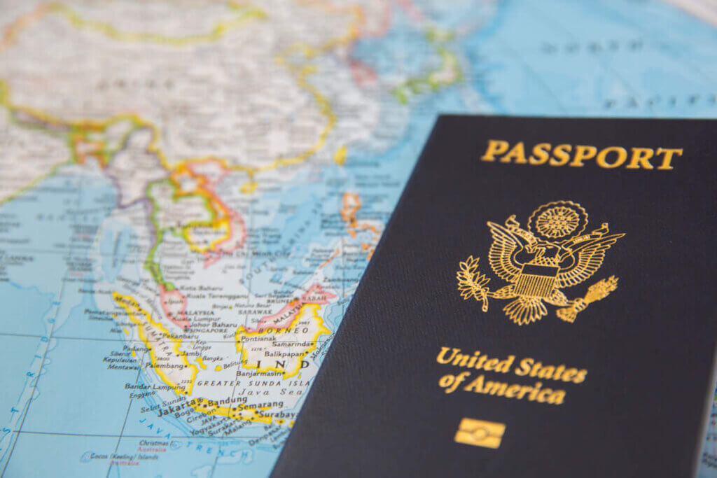 Wondering if you need a passport to visit Hawaii? As long as you are visiting from the US, you don't! Image of a US passport on top of a world map.