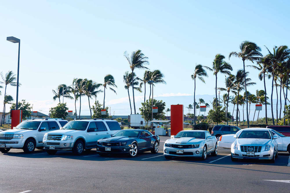 Find out where to get cheap Maui car rentals recommended by top Hawaii blog Hawaii Travel with Kids. Image of a bunch of renal cars in Hawaii.