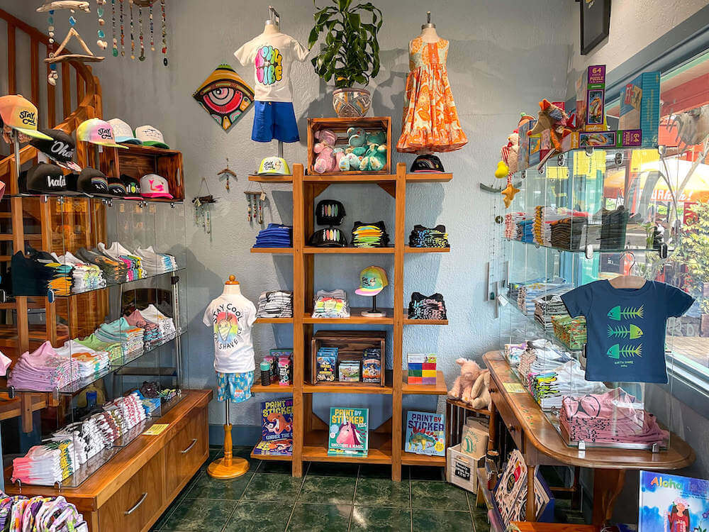 Tini Manini is a super cute Oahu baby store located on the North Shore. Image of the interior of a Hawaii baby store with t-shirts, books, hats, and toys.