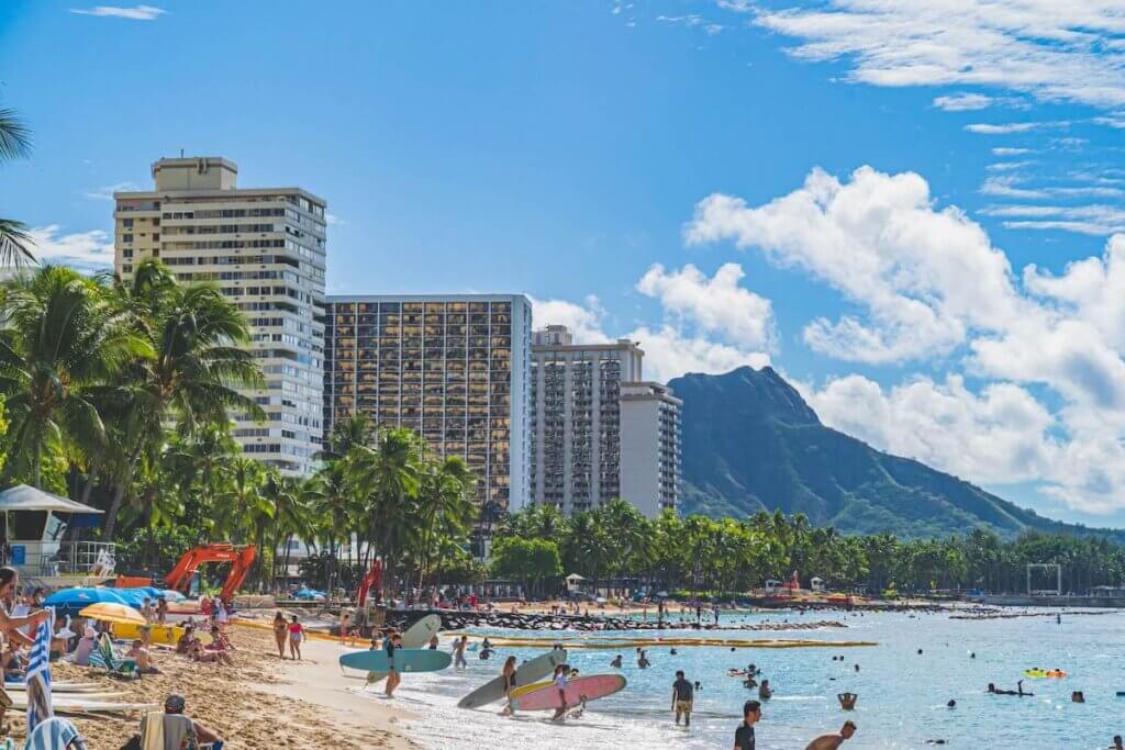 Image of Waikiki Beach on Oahu with surfers, hotel buildings, and Diamond Head in the background