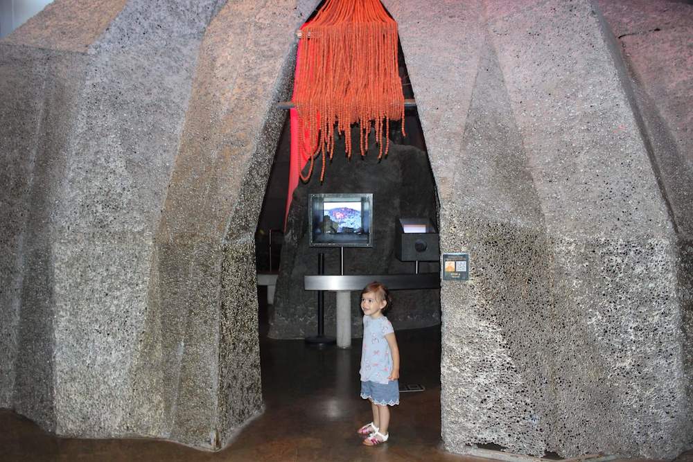 Image of a girl standing in a volcano exhibit at Bishop Museum in Hawaii.