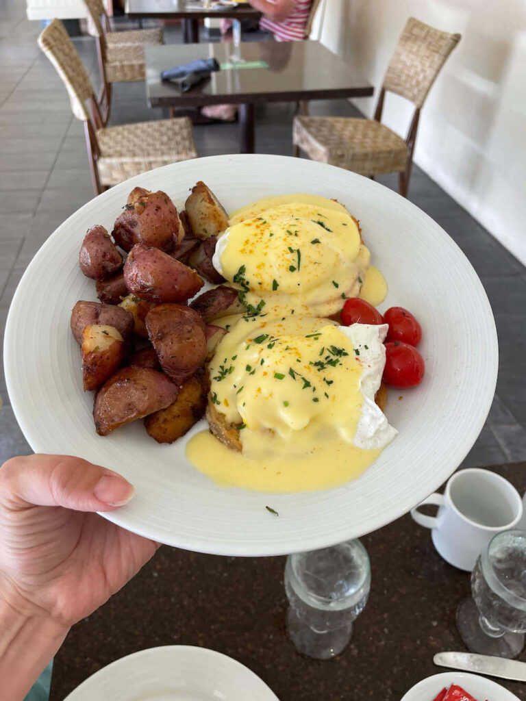 Where to stay on Kauai with kids: Royal Sonesta Kauai review. Image of a plate of Eggs Benedict at Kukui's on the Beach.