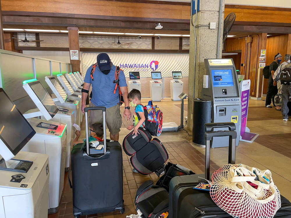 Image of a dad and son checking bags at the Lihue Airport on Kauai.