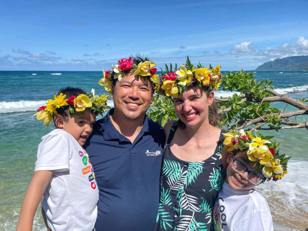 Find out how to make a haku lei on Oahu by top Hawaii blog Hawaii Travel with Kids. Image of a family wearing flower crowns in Hawaii.