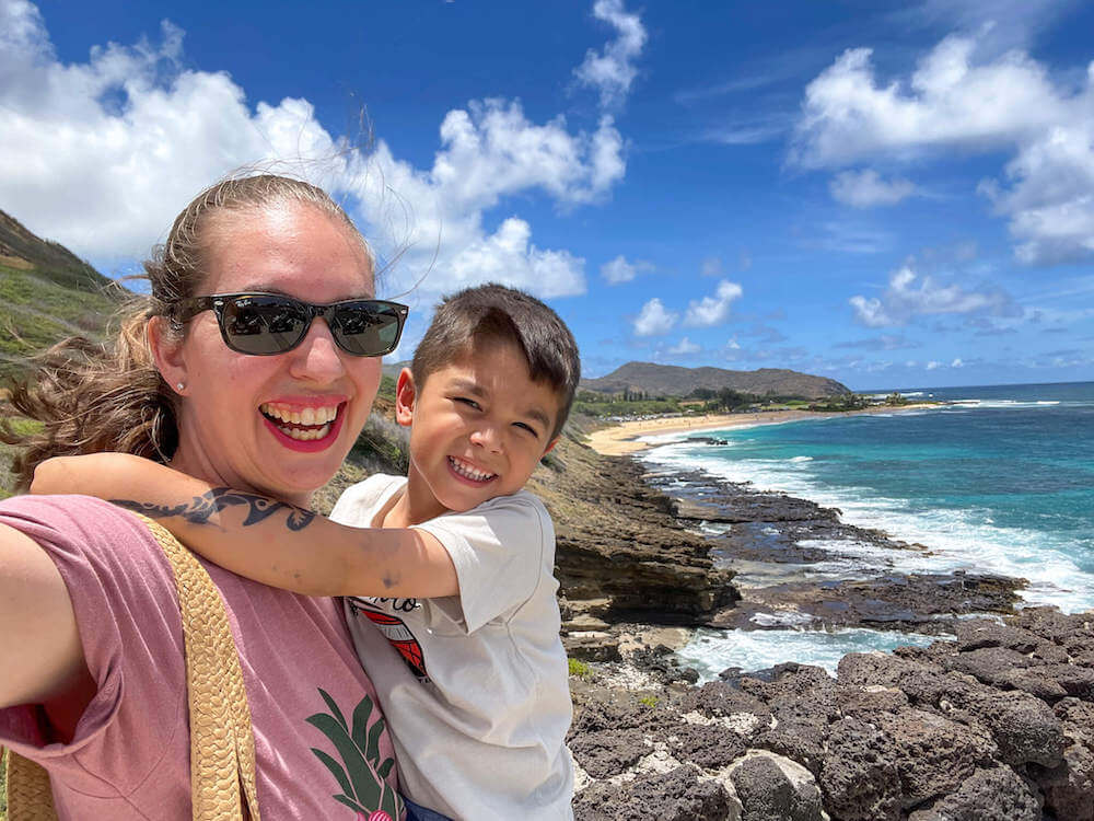 The Waikiki Trolley Blue Line makes a stop at Halona Blowhole. Image of a mom and boy at a blowhole in Hawaii.