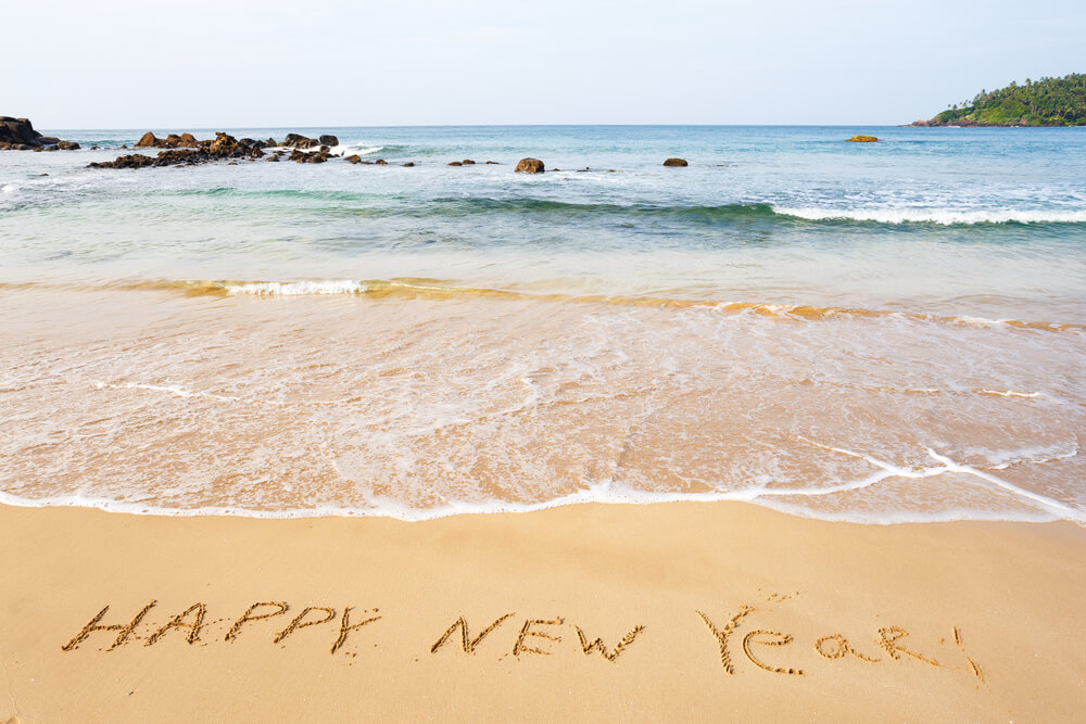 Image of the words Happy New Year written in the sand at a beach in Hawaii for New Year's Eve