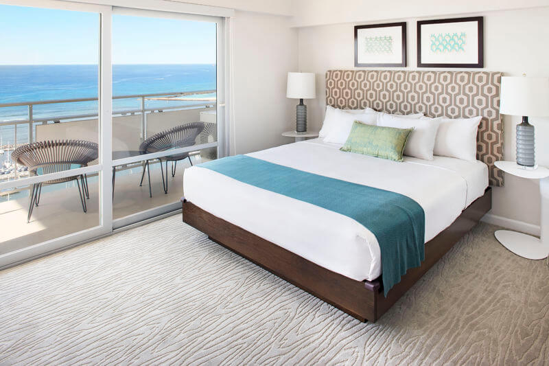 The Ilikai Hotel & Suites is one of the best places to stay in Honolulu, Hawaii. Image of a clean hotel room with a view of the Pacific Ocean.