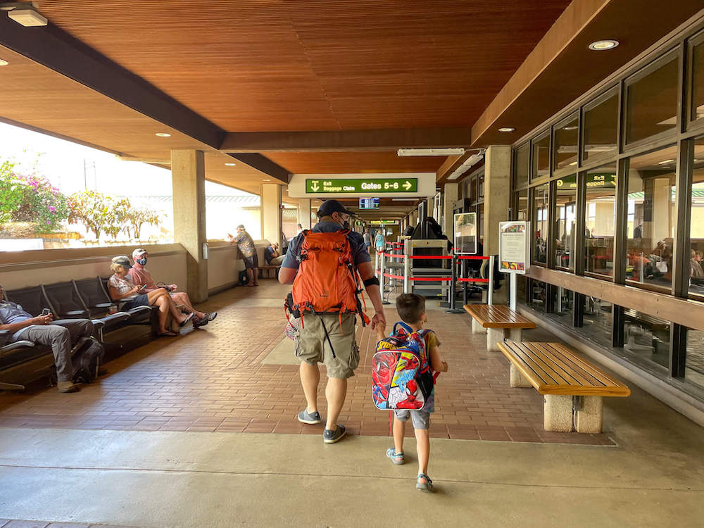 Image of a dad and son walking through the Lihue Airport on Kauai.