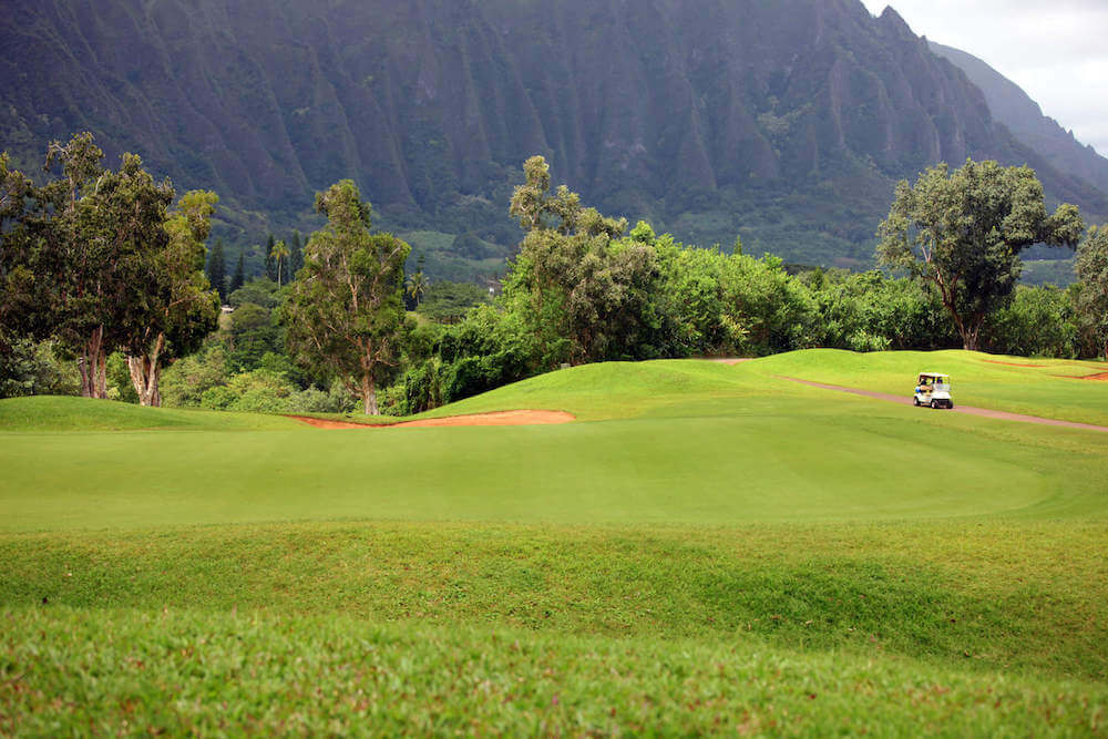 One of the best things to do in Kaneohe Hawaii is go golfing! Image of a golf course with Ko'olau mountains in the background.