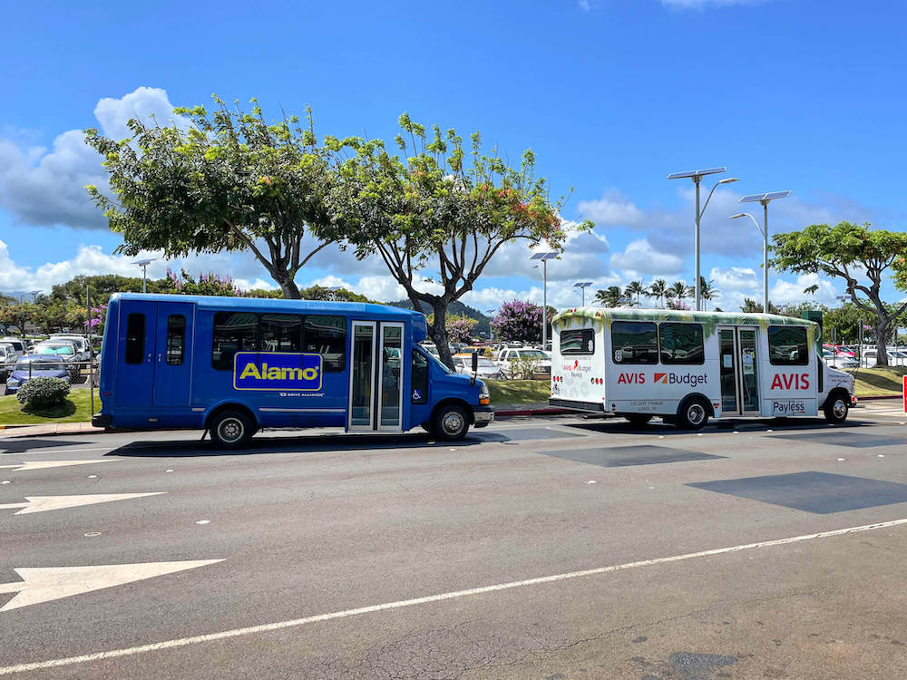 You'll want to rent a car on Kauai. They have car rental shuttles at the Lihue Airport. Image of the Alamo and Avis car rental shuttle buses.