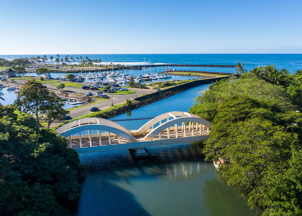 The Rainbow Bridge in Haleiwa is one of the most Instagrammable places on Oahu. Image of a double arched bridge over a stream on Oahu.