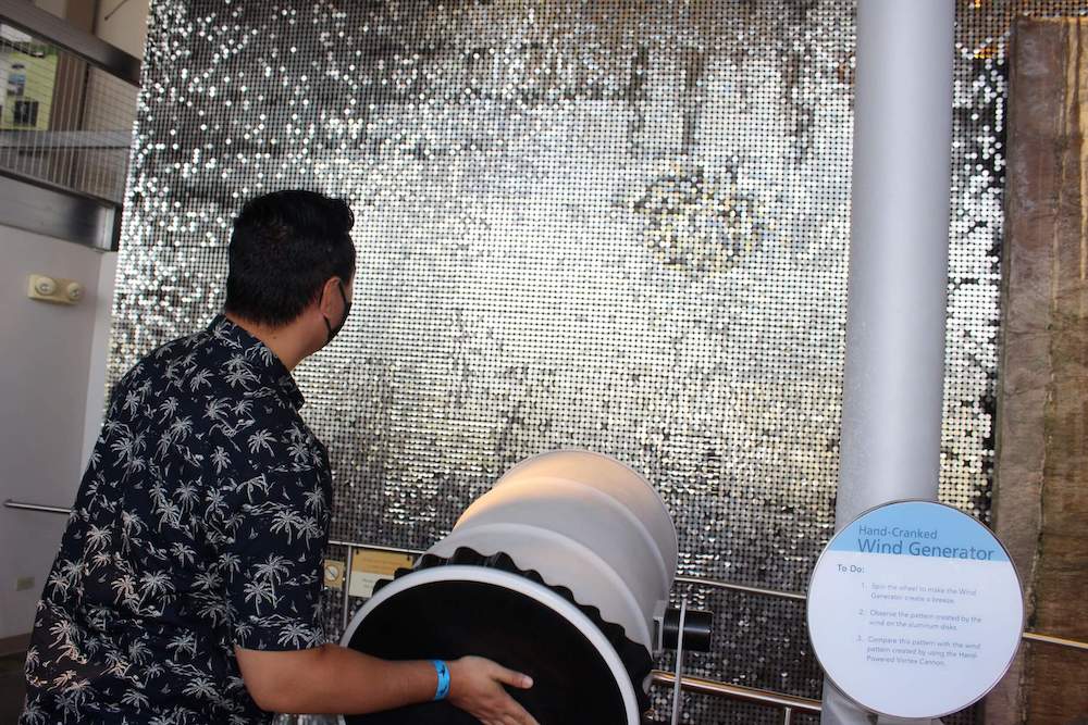 The science center at Bishop Museum on Oahu is pretty cool! Image of a dad playing with the hand-cranked wind generator.