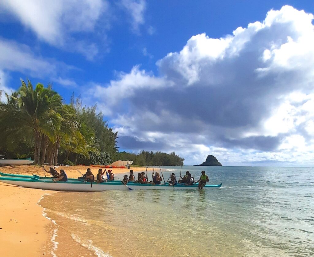 Find out what to do on Secret Island Oahu by top Hawaii blog Hawaii Travel with Kids. Image of a Hawaii beach and canoe