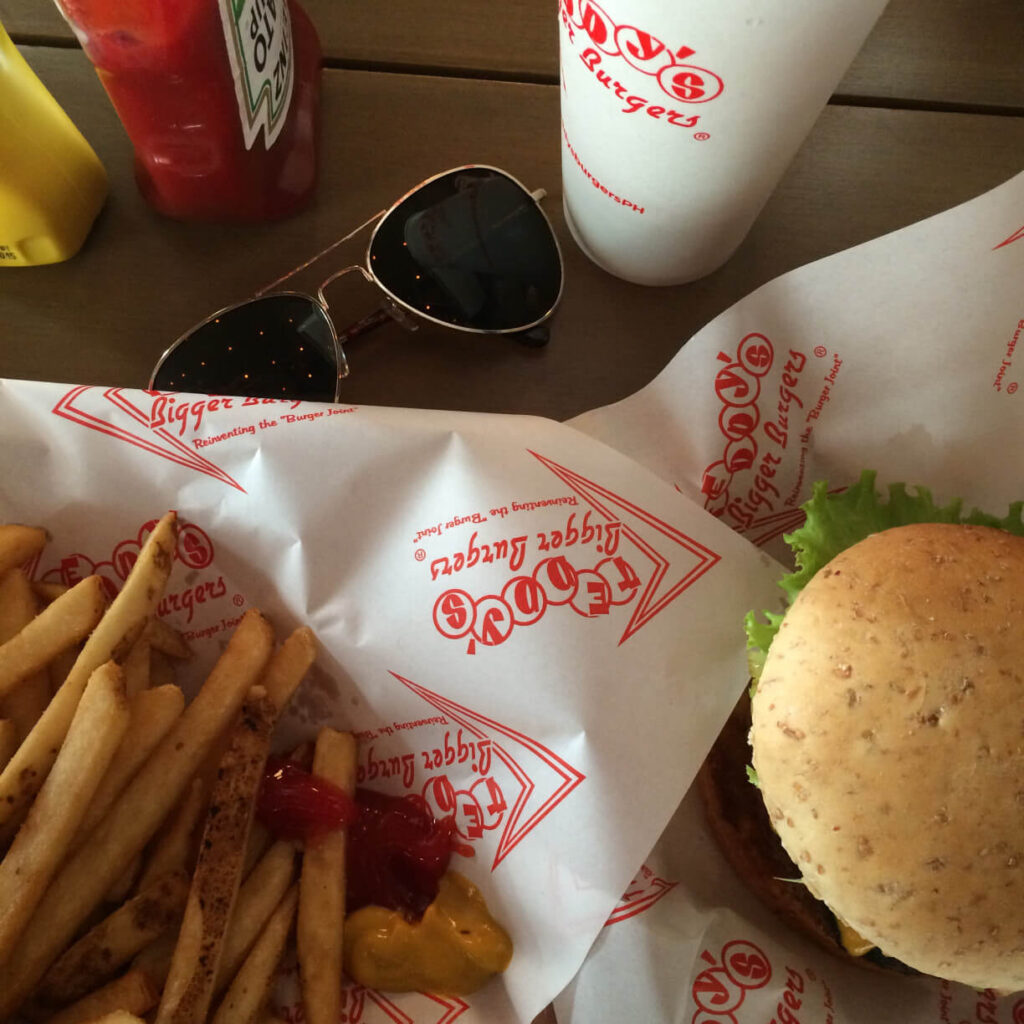 Image of a burger, fries, and sunglasses on a table