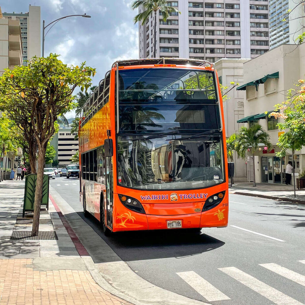 Read this honest Waikiki Trolley review by top Hawaii blog Hawaii Travel with Kids. Image of a red trolley in Waikiki.