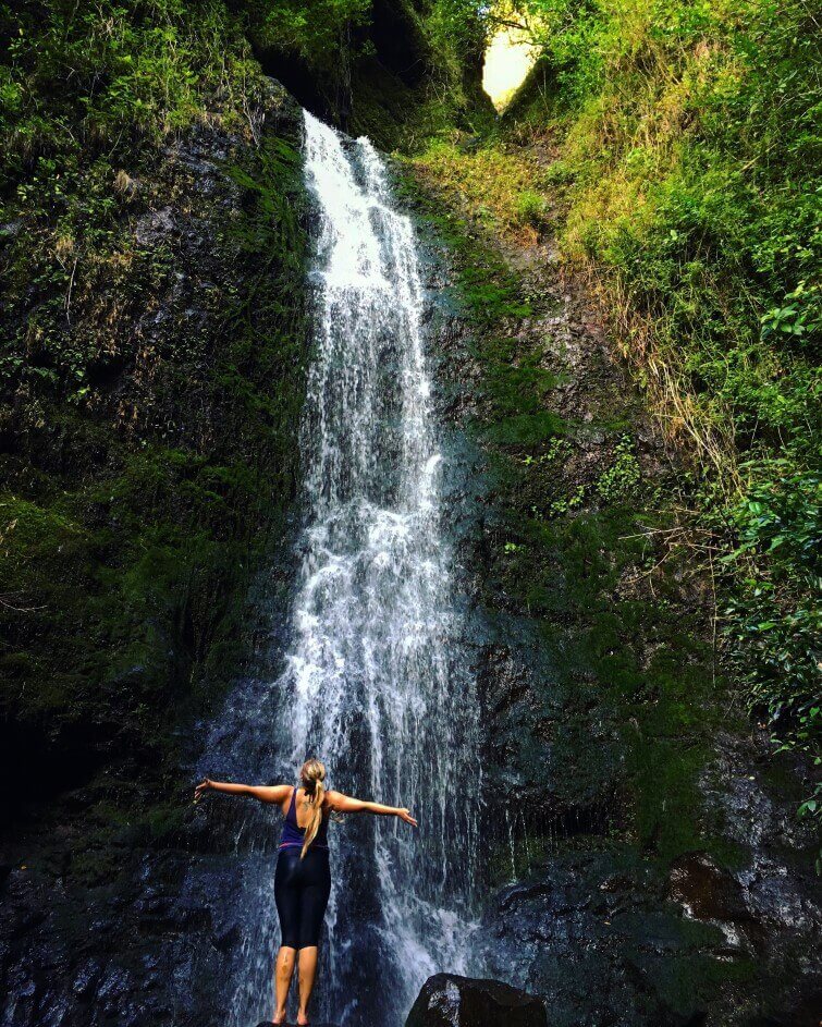 Lulumahu Falls is one of the prettiest waterfall hikes on Oahu. Image of a woman standing in front of an Oahu waterfall.