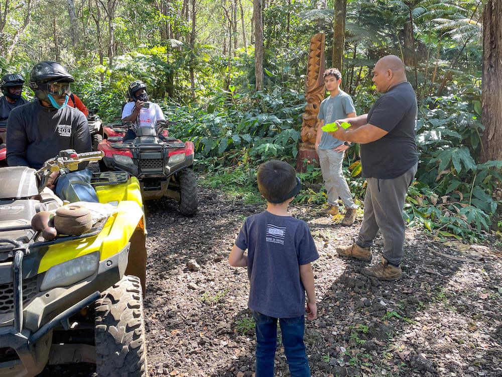 Image of a man teaching people on ATVs about taro root in Hawaii.